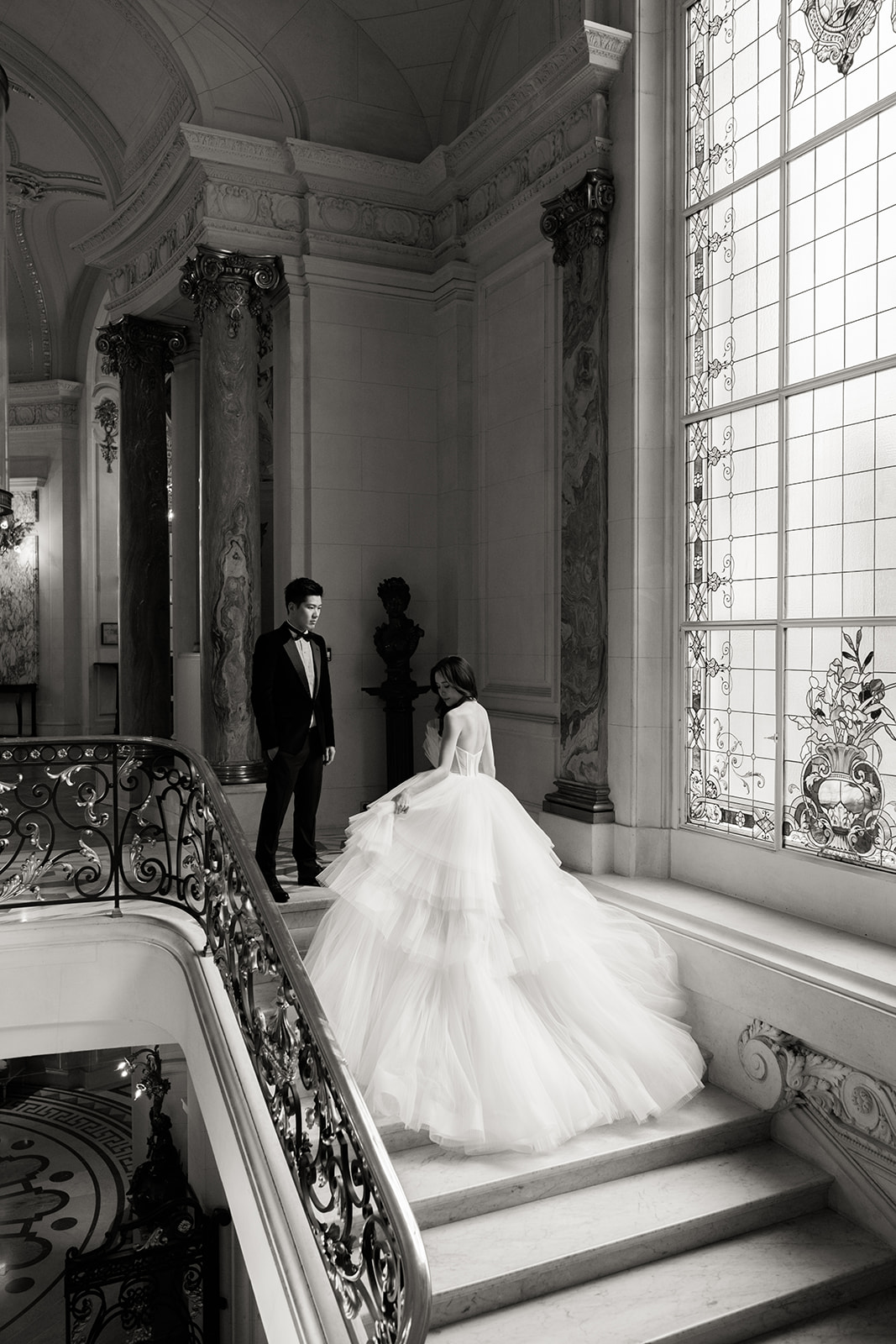 une mariée est sur la terrasse de la suite shangri-la et il y a la tour eiffel derriere elle